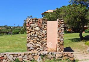 un muro di pietra con un monumento in un campo di Suite Fronte Mare - Brezza Dorata a Porto Rotondo