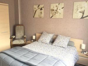 a bedroom with a bed and a chair at Couleur Framboise in Longwy