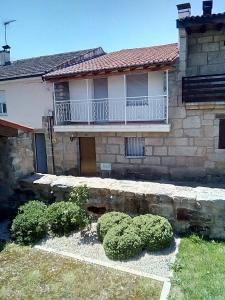 a house with a balcony and bushes in front of it at A Casa da Boa Xente VUT-OU-1329 in Verín