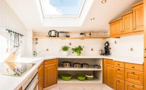 a kitchen with wooden cabinets and a skylight at Wildgrün Panorama Lodge 8b in Pfronten