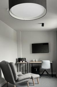 a living room with a chair and a flat screen tv at Kamienica nr 6 in Aleksandrów Łódzki
