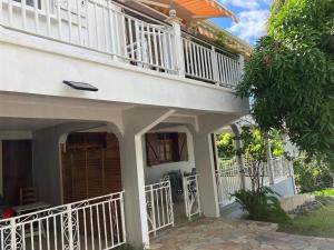a white house with a balcony and a patio at La Maison d 'Hippolyte in Vieux-Habitants