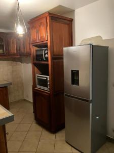 a kitchen with a stainless steel refrigerator and a microwave at La Maison d 'Hippolyte in Vieux-Habitants