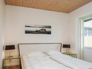 a white bed in a white room with two lamps at 4 person holiday home in Nørre Nebel in Nørre Nebel