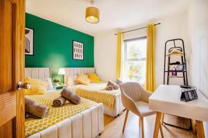 1 Schlafzimmer mit 2 Betten und einer grünen Wand in der Unterkunft Central Urban Retreat Oasis Free Parking 13ppl in Sheffield