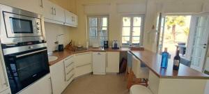 a kitchen with white cabinets and a wooden counter top at Appartement Fenia in Las Manchas