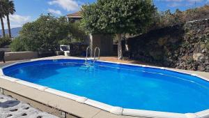a large blue swimming pool with a chair in it at Appartement Fenia in Las Manchas +25 photos