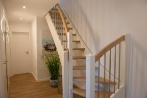 a white staircase in a home with a plant at Mole rechts in Norden
