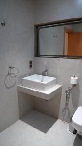 a bathroom with a white sink and a toilet at Suites El Ghailani in Dakhla