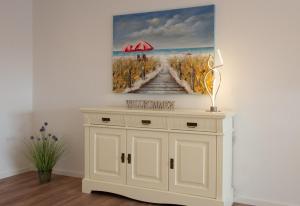 a painting on a wall above a white cabinet at Deichnähe - E in Norden