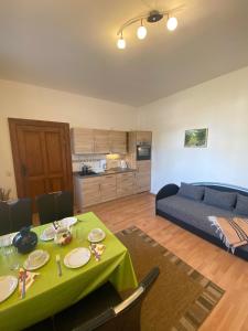 a living room with a green table and a bed at Haus H&M Ferienwohnung 4 in Rehfelde