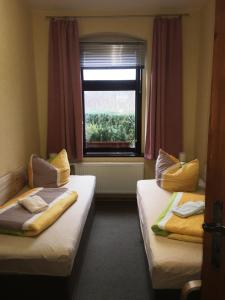 two beds in a room with a window at Haus H&M Ferienwohnung 4 in Rehfelde