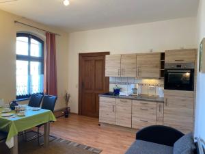 a kitchen with wooden cabinets and a table with chairs at Haus H&M Ferienwohnung 4 in Rehfelde
