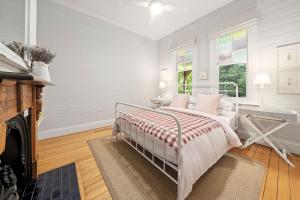 Un dormitorio blanco con una cama y una chimenea. en Brechin Cottage, en Blackheath 19 fotos más