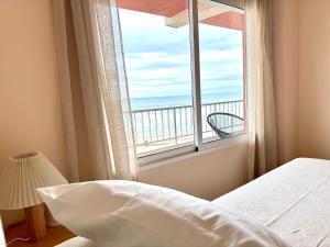 a bedroom with a bed and a view of the ocean at Casa Palmera in Sueca