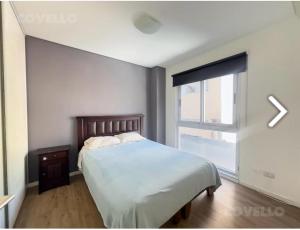 a bedroom with a large bed and a window at Departamento 3 amb para 5 personas con gimnasio, cochera y piscina in Buenos Aires
