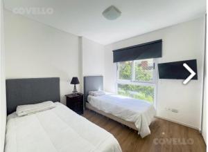 a bedroom with two beds and a window at Departamento 3 amb para 5 personas con gimnasio, cochera y piscina in Buenos Aires