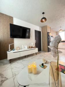 a living room with a tv and a table with candles at Hermoso Departamento, WiFi, terraza vista al Lago de Pátzcuaro, elevador, free parking in Pátzcuaro