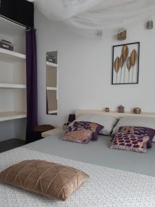 a bedroom with two beds with pillows on them at Villa JAJA Piscine-Climatisation in Poponguine