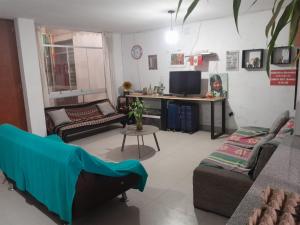 a living room with two couches and a table at Chakraruna Backpackers in Cajamarca