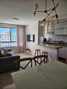 a kitchen and living room with a couch and a table at Apartamento Ilhéus in Ilhéus