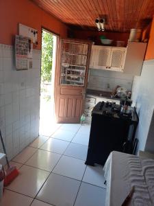 una cucina con piano cottura e una porta che conduce a una camera di Residência do Roberto a Rosário do Sul