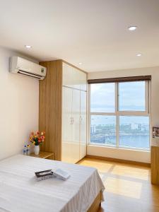 Un dormitorio con una cama y una ventana grande en Homestay Bãi Cháy HaLong 1 2 3 5 phòng ngủ Liên hệ em tư vấn, en Ha Long