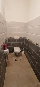 a bathroom with a toilet in a tiled room at Appartement de type F3 in El Kseur
