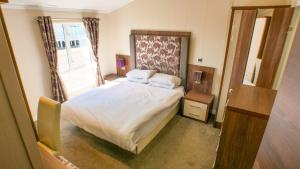 a small bedroom with a bed and a window at 3 Bed 2 Bathroom Super Lodge! Sea Views! in Exmouth