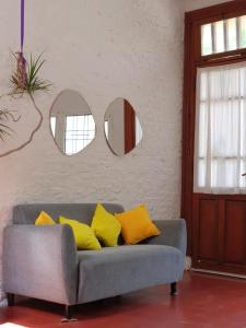 a couch with yellow pillows in a room with mirrors at Casa María Josefina in Rosario +26 photos