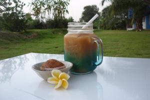 a jar of honey and a cupcake and a flower on a table at Maneemudjalin Resorts Farm Stay in Sam Roi Yot