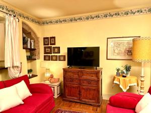 a living room with a red couch and a flat screen tv at Luxury Deco Painter Ca' Dottori Perugia in Perugia +29 photos