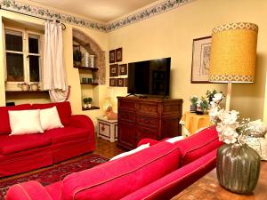 a living room with a red couch and a tv at Luxury Deco Painter Ca' Dottori Perugia in Perugia