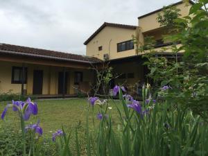 a garden with purple flowers in front of a house at 麵包樹舍 Breadfruit B&B in Guangfu