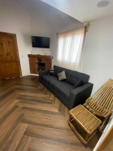 a living room with a black couch and a television at Cabañas lindo amanecer in Huasca de Ocampo