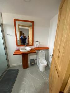 a man taking a picture of a bathroom with a toilet at Cabañas lindo amanecer in Huasca de Ocampo