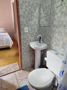 ein Badezimmer mit Toilette und Waschbecken in der Unterkunft Chalé do Ypê 2 in Pirenópolis