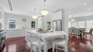 eine weiße Küche mit einer weißen Insel in einem Raum in der Unterkunft Time Space in Pokolbin