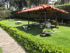 Los AranaにあるHospedajeRancholajoya-Habitacion Fresnoの庭園(パラソル、椅子、テーブル付) +4枚の写真