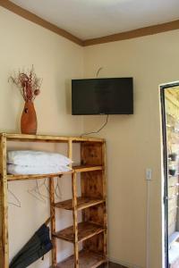 Los AranaにあるHospedajeRancholajoya-Habitacion Fresnoの壁にテレビと棚が備わる部屋