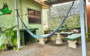 a hammock and a bench in front of a house at Casa Cattleya - Monteverde, Costa Rica in Monteverde Costa Rica