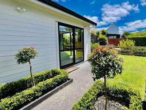 a house with two trees in front of it at Riverhead Homestead Self-Contained Studio Apartment in Riverhead