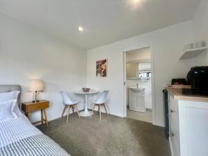 a bedroom with a bed and a table and chairs at Riverhead Homestead Self-Contained Studio Apartment in Riverhead