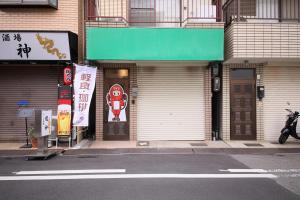 ein Gebäude mit Türen an der Straßenseite in der Unterkunft おまつりハウス in Osaka