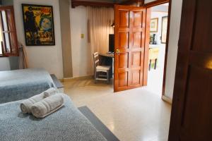 a bedroom with two beds and a door with a desk at Casa Nazimova Indigo Room in San Cristóbal de Las Casas