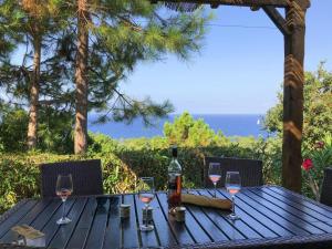 un tavolo in legno con bicchieri da vino e una bottiglia di Apartment in Corsica near Sandy Beach a Favone