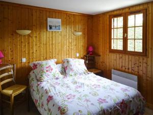 Un dormitorio con una cama y una pared de madera. en Wooden House by Beach near Barneville, en Denneville