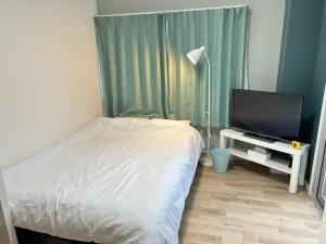 a bedroom with a bed and a flat screen tv at SABBATH uzumasa 201 in Kyoto