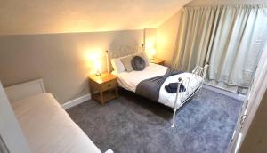 a bedroom with two beds and a window with curtains at Ravenshaw House Parking Maidstone 4 Bed Garden in Maidstone