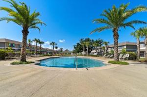 a swimming pool with palm trees and condos at Pensacola Paradise Downtown in Pensacola